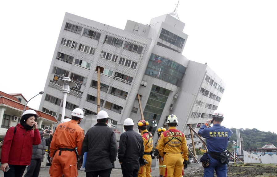 Rescuers from Japan join the searching operation at an apartment building collapsed after a strong earthquake in Hualien County, eastern Taiwan, Friday, Feb. 9, 2018. A magnitude 6.4 earthquake struck late Tuesday night caused several buildings to cave in and tilt dangerously.