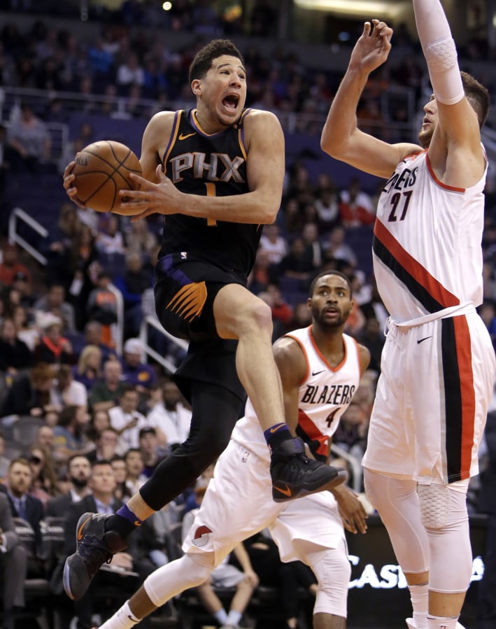 Phoenix Suns guard Devin Booker (1) drives on Portland Trail Blazers center Jusuf Nurkic during the second half of an NBA basketball game Saturday, Feb. 24, 2018, in Phoenix. The Trail Blazers defeated the Suns 106-104.