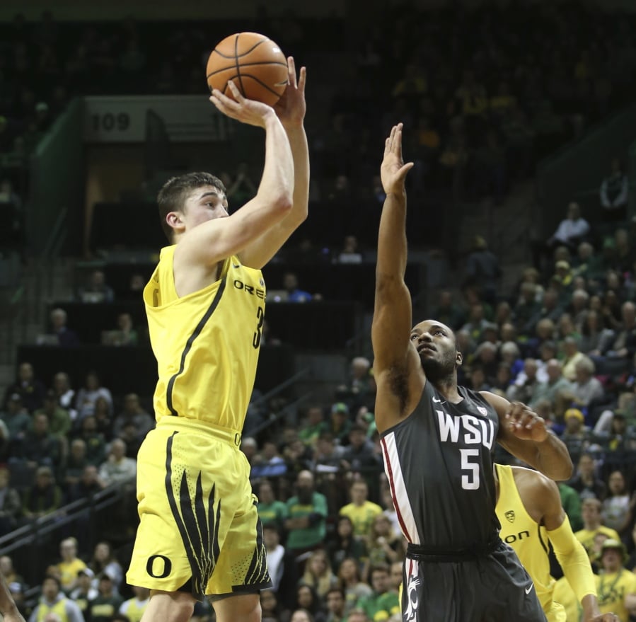 Oregon’s Payton Pritchard, left, shots over Washington State’s Milan Acquaah during the first half of an NCAA college basketball game Sunday, Feb. 11, 2018, in Eugene, Ore. Oregon won, 84-57.