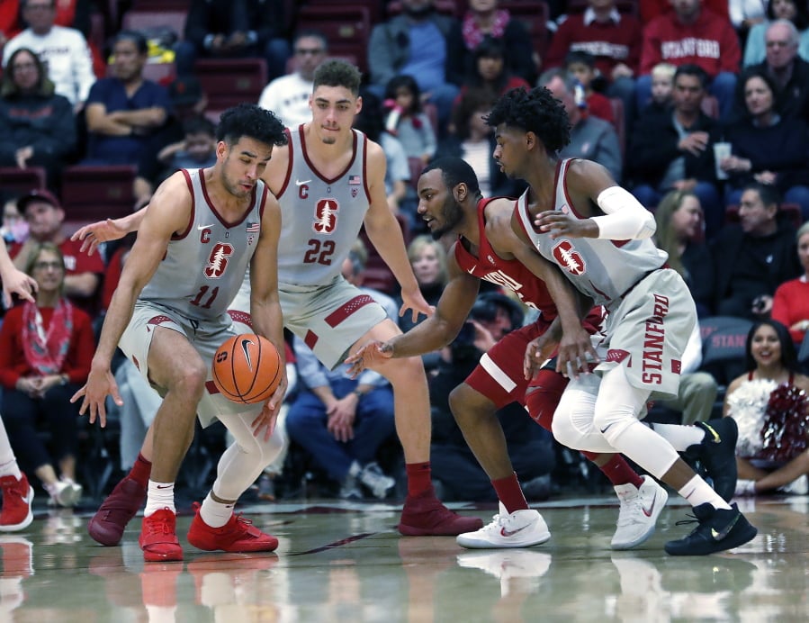 Stanford guard Dorian Pickens (11) steals the ball from Washington State guard Milan Acquaah (5) as Stanford guard Daejon Davis, right, defends during the first half of an NCAA college basketball game Saturday, Feb. 24, 2018, in Stanford, Calif.