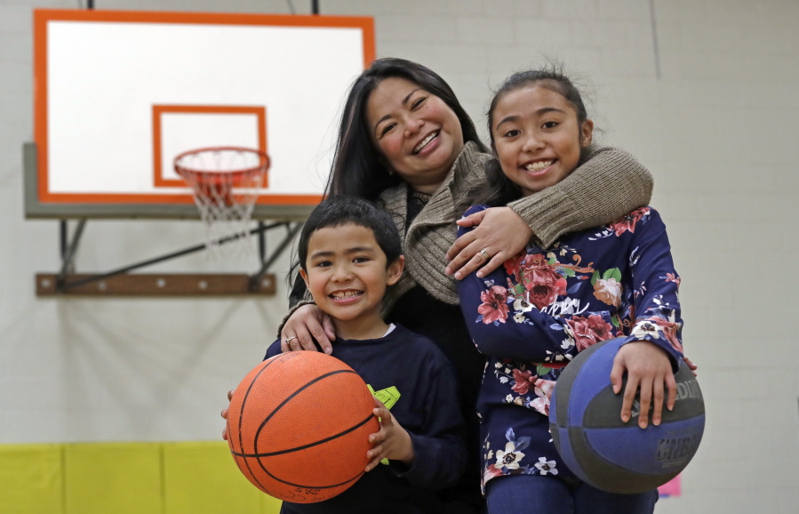 Lara Mae Chollette, a coach of youth soccer and basketball, poses for a photo with her son Jaylen, 7, left, and daughter Linda, 10, at a community gym in Seattle. Horrific cases and allegations of predatory crimes against youth in gymnastics, swimming and football, among other sports, have jolted many parents who say they believe sports can be an important part of their child’s development. Some now feel compelled to take a more cautious approach in monitoring adult interactions, as advancement beyond pee-wee leagues become increasingly coach-driven.