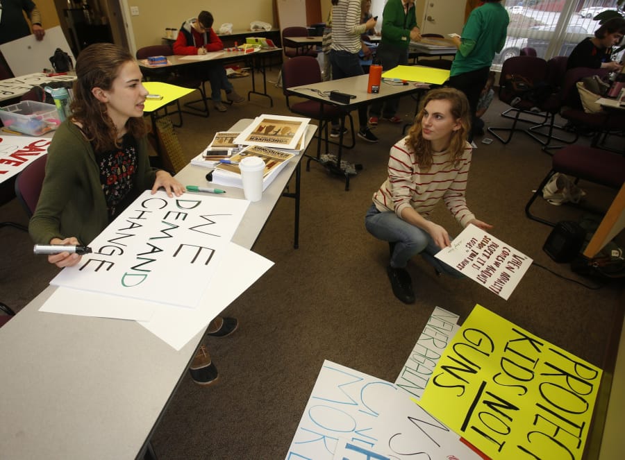 Vancouver School of Arts and Academics students Greta DuBois, left, and Aubree Radtke make signs at the Evergreen Education Association offices for the March for Our Lives, scheduled for Saturday. They’re among a group of student organizers leading the upcoming demonstration.