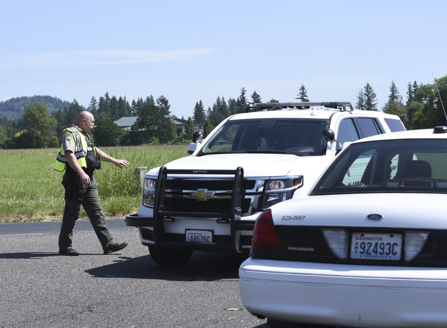 A sheriff’s deputy helps control the scene after police shot and killed a bank robber last June. The shooting was ruled justified after an investigation.