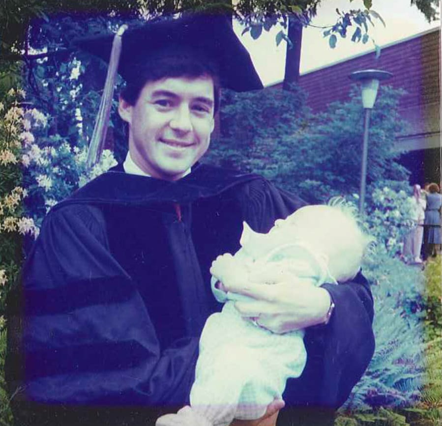 Barry Brandenburg holds his son Bennett on the day of his graduation from law school.
