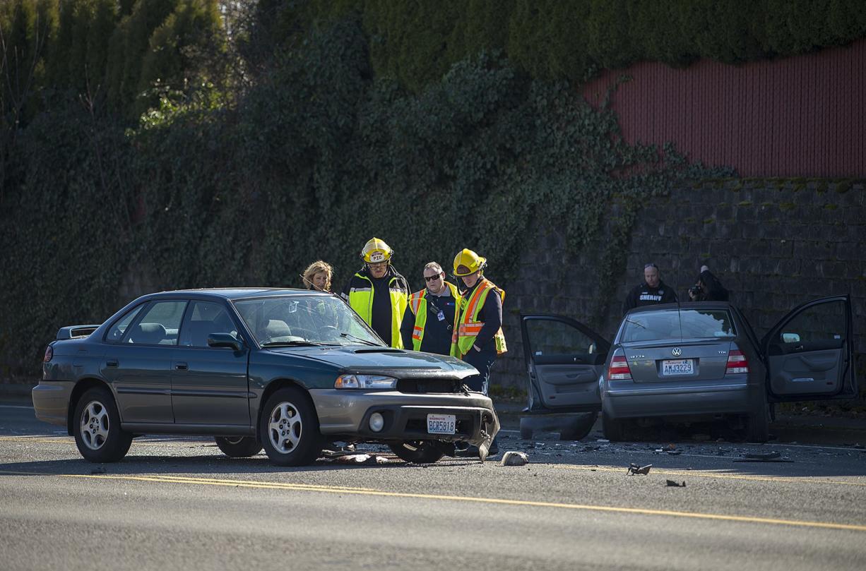 Officials look over the aftermath of a crash between a Subaru Legacy, foreground, and a Volkswagen Jetta near Columbia River High School on 99th Street on Tuesday morning, March 6, 2018. One person was confirmed dead in the crash.