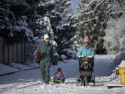 Tai Ledah, from left, heads out Feb. 21 with his daughter, Naomi, his wife, Anne, and their baby, Ebony, on their way to Franklin Elementary School in Vancouver for a morning of fun in the snow.