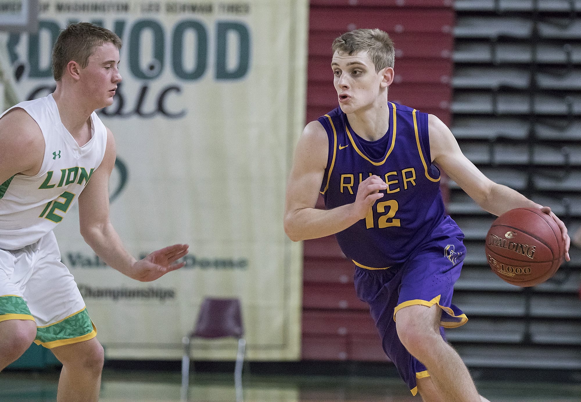 Columbia River's Jacob Hjort (12) drives past Lynden's Brock Heppner (12) during the WIAA 2A boys state basketball tournament on Thursday, Mar. 1, 2018, at the Yakima Valley SunDome. Lynden Lions defeated Columbia River Chieftains 44-33.