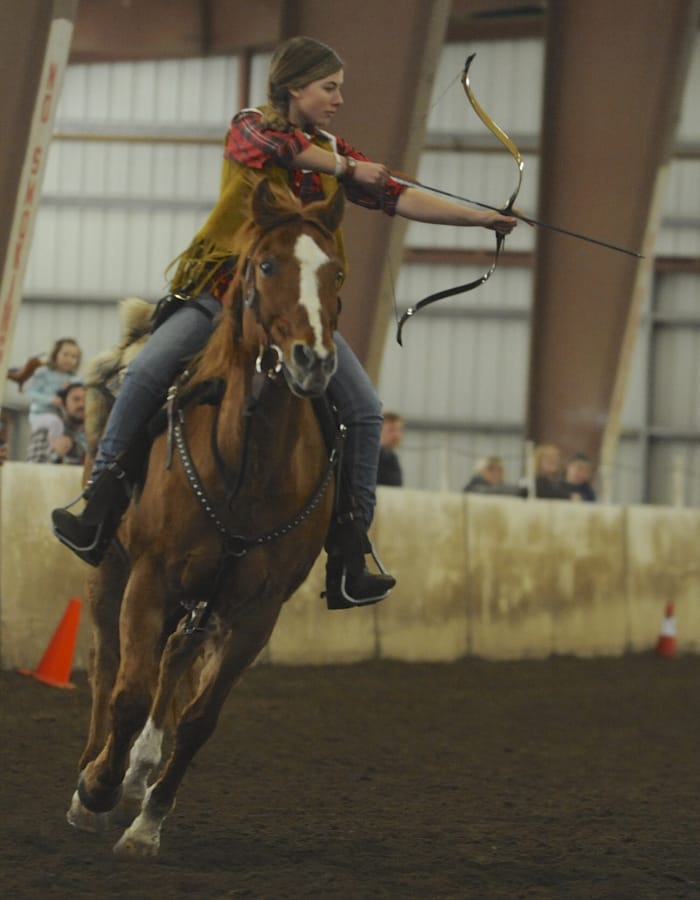 Trinity Massie, front, sets up for a shot during the mounted archery demonstration Sunday afternoon at the Washington State Horse Expo. The Brush Prairie-based Volcano Ridge Mounted Archers put on the exhibition.