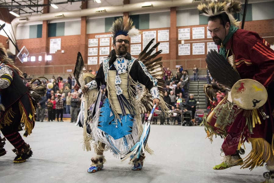 Louis Kameroff of Vancouver and of the Yupik and Modoc tribes, center, and Corey Nasewytewa of Beaverton, Ore., and of the Hopi and Gila River Pima tribes, right, dance during the grand entry parade Saturday at the annual Traditional Pow Wow hosted by the Native American Parent Association of Southwest Washington. Hundreds of people attended to watch dozens of dancers and drummers perform.