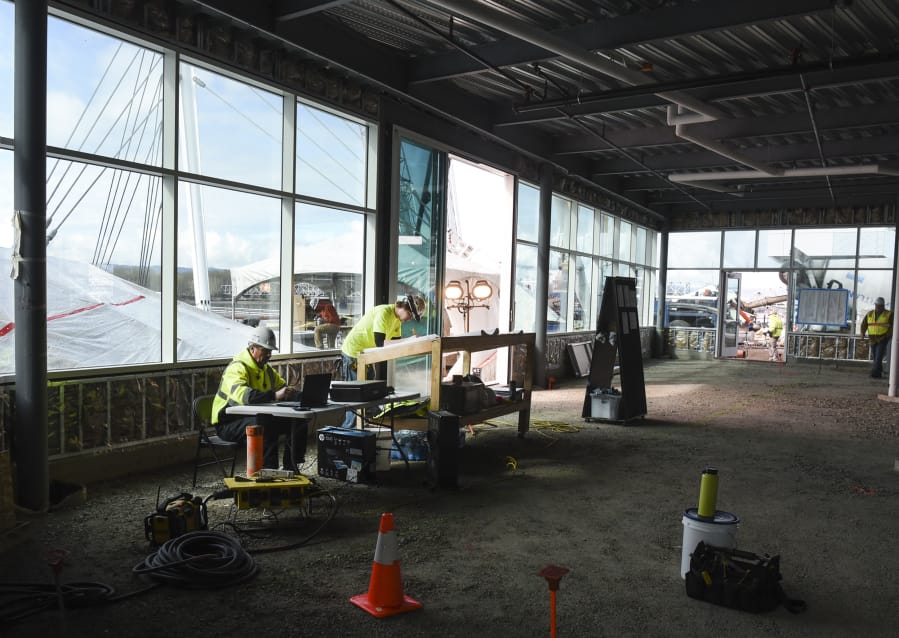 Terry Koker, left, and Brandon Koumaros of R. Miller Construction look over plans for WildFin American Grill inside the restaurant. The restaurant officially took occupancy Monday at The Waterfront Vancouver. It is expected to open in August.