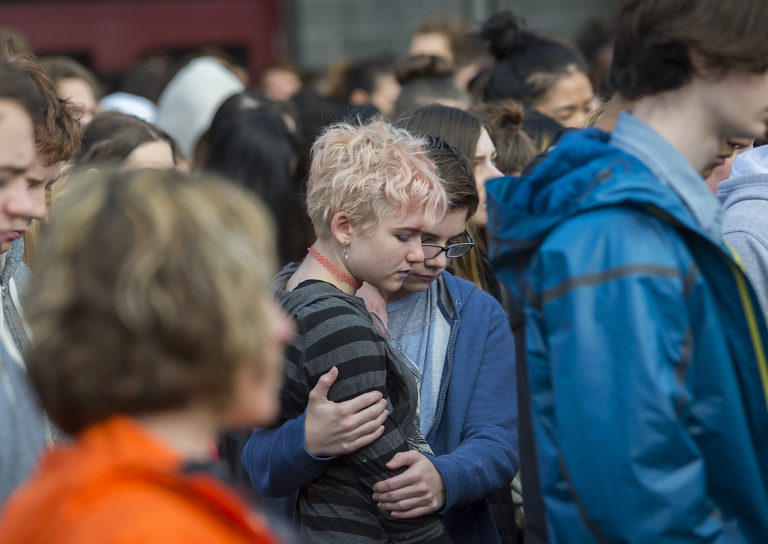 Camas High School sophomore Shannon McDaniel, 16, in stripes, and freshman Caleb Ashworth, 15, pause in a moment of silence outside their school Wednesday morning, March 14, 2018 to honor the memory of the 17 people killed in the Marjory Stoneman Douglas High School shooting in Parkland, Fla. The Camas school walkout was among the many that took place in high schools around the country.