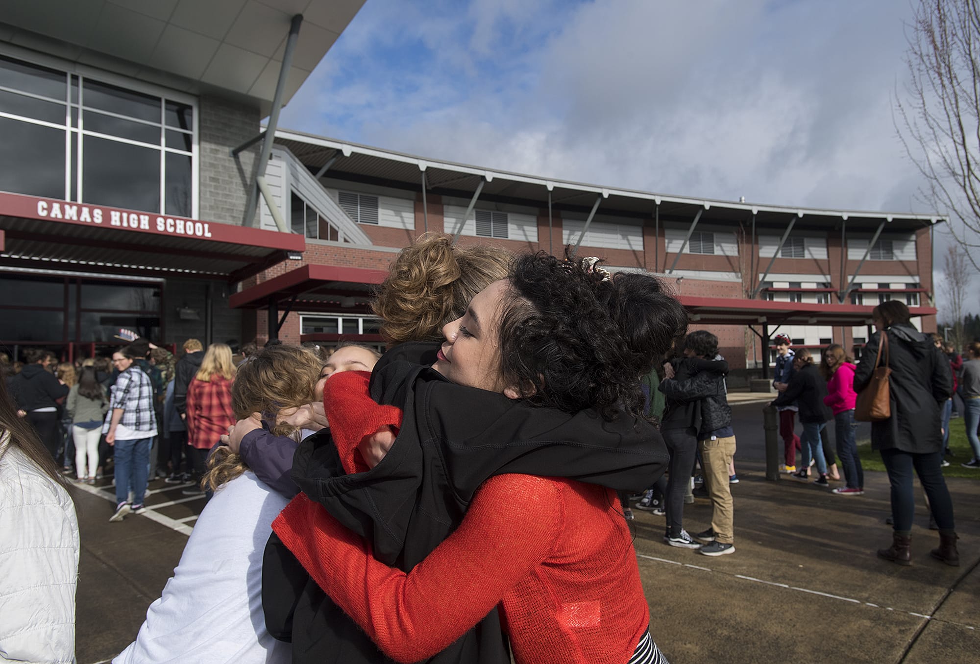 Camas High School freshman Jaryn Lasentia, 15, in black, embraces fellow freshman Willow Buffett, 14, before returning to class after the school walkout to protest gun violence Wednesday morning, March 14, 2018. The walkout was one of many held across the country honoring those killed in the Parkland, Fla., shooting that left 17 people dead.