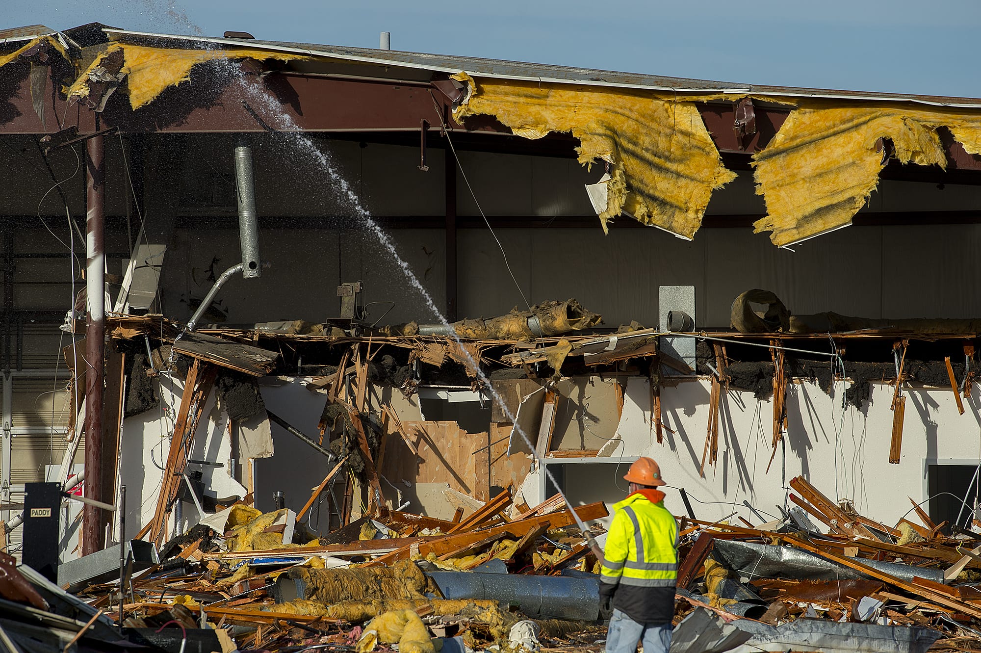 Josh Miller of JM Knelleken Company wets down materials during demolition of the former Petlock building in downtown Vancouver on Monday morning.