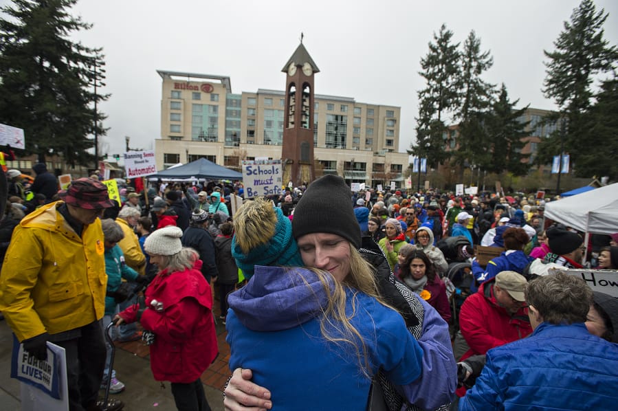 Heather Freitag of Vancouver, facing, embraces her daughter, Matthea Freitag, 12, after the March For Our Lives rally at Esther Short Park on Saturday afternoon. Matthea Freitag, one of the students who spoke to crowd, shared what it is like to live with the threat of a shooting at her school. About 1,000 people attended the marches and rally.