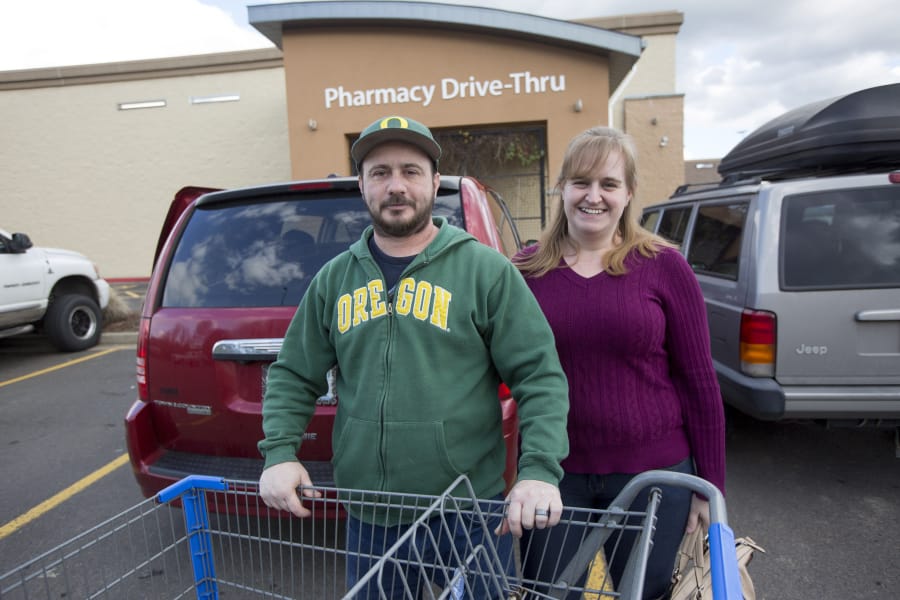 Chris and Jennifer Waller stand in the Walmart parking lot in Battle Ground after a shopping trip. The family is one of many in Clark County who earn below the median wage and have not seen wages rise even as the economy as thrived.
