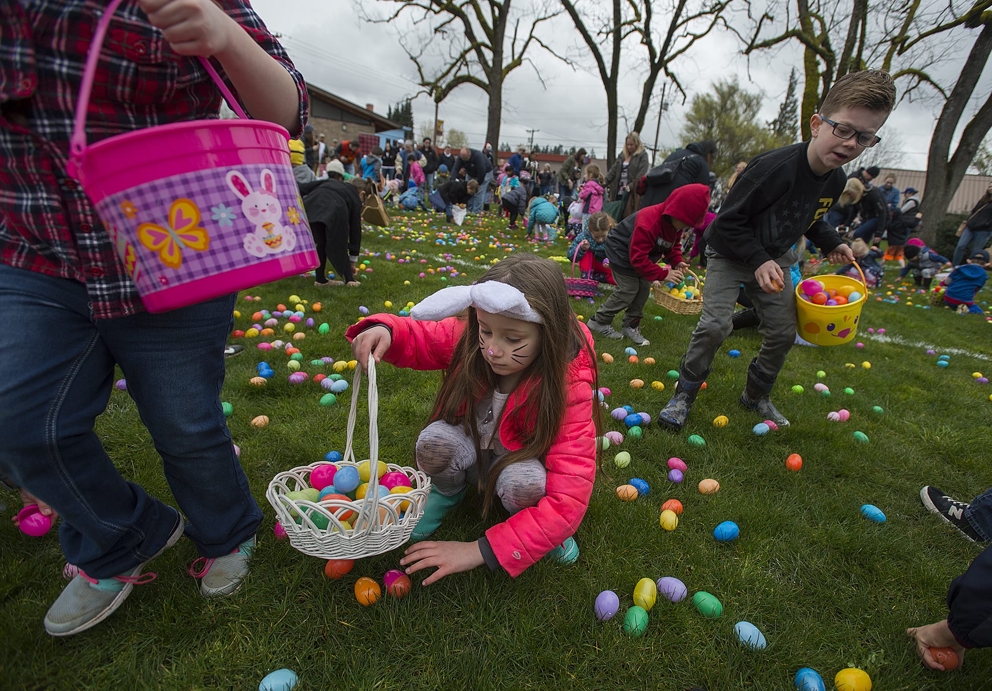 Hadley Hamilton, 6, of Ridgefield, center with bunny ears, joins the hunt for Easter eggs during the egg hunt at Overlook Park in Ridgefield on Saturday morning.