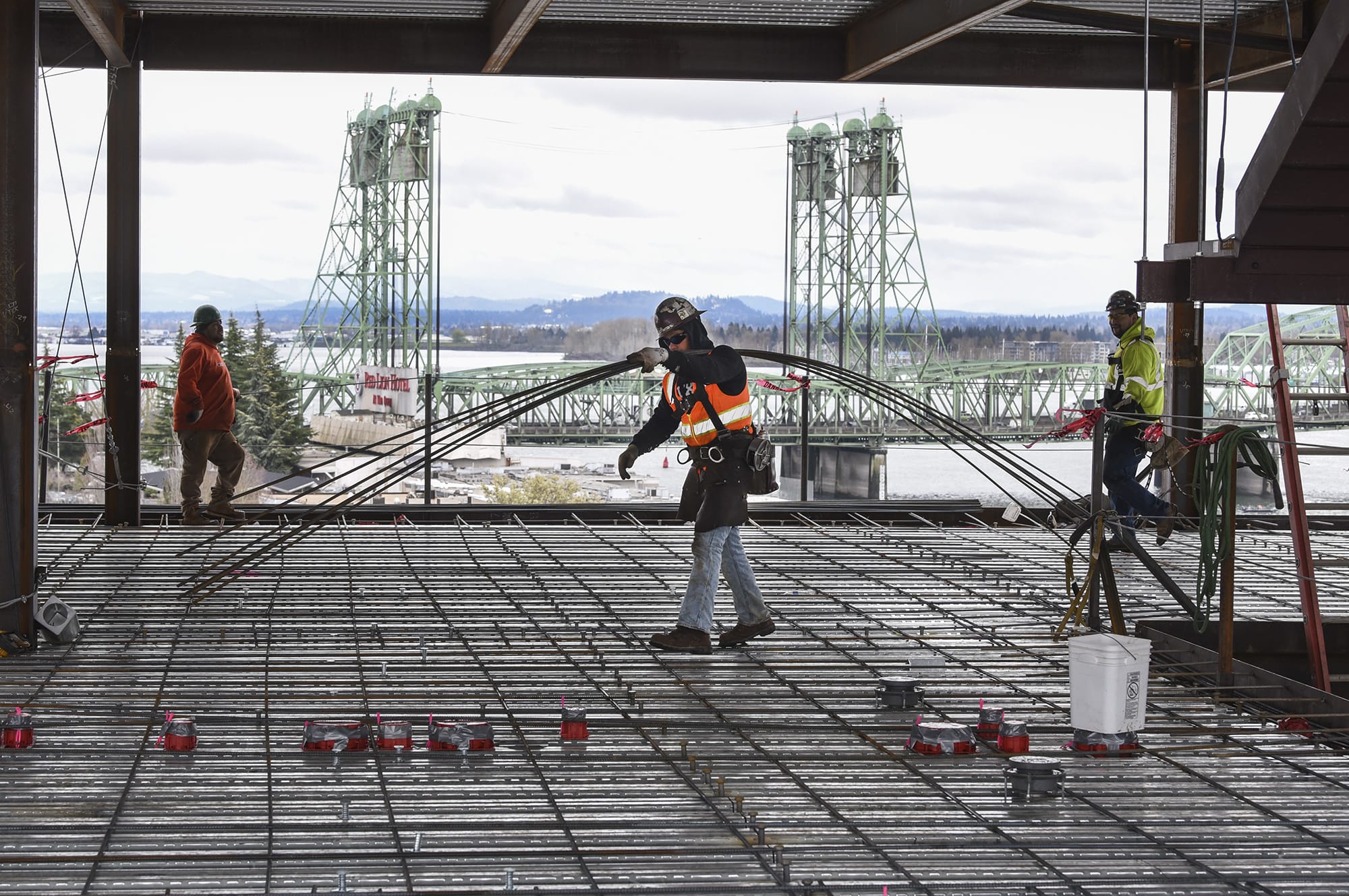 Fidel Camacho, center, of Farwest Steel, moves rebar on the sixth floor of the seven-story office tower at the Vancouver waterfront, Friday March 23, 2018. Crews were laying down rebar Friday to prepare for pouring concrete on the sixth floor this coming Monday.