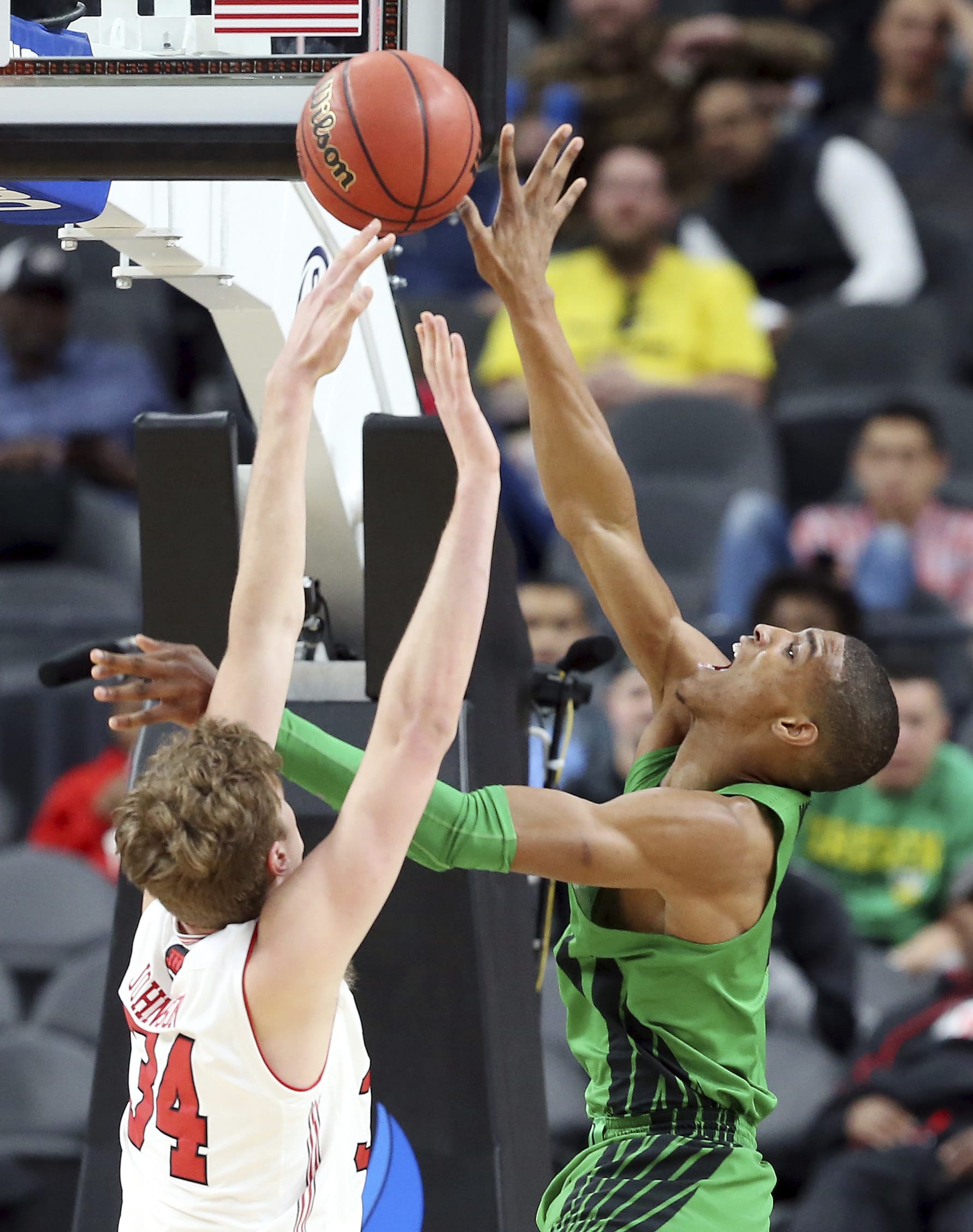 Oregon's Kenny Wooten, right, shoots while covered by Utah's Jayce Johnson during the second half of an NCAA college basketball game in the quarterfinals of the Pac-12 men's tournament Thursday, March 8, 2018, in Las Vegas. Oregon won 68-66.