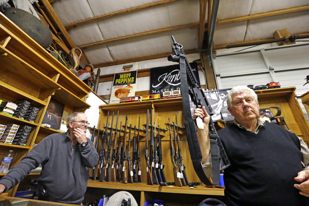 FILE- In this Oct. 20, 2017 file photo, sales clerk Tom Wallitner holds up a Mossberg 715T .22-caliber semi-automatic rifle during an auction at Johnny's Auction House, where the company handles gun sales for a half dozen police departments and the Lewis County Sheriff's Office, in Rochester, Wash. The Washington state Legislature ended the session without passing a bill that would allow the State Patrol to destroy firearms confiscated during criminal investigations.
