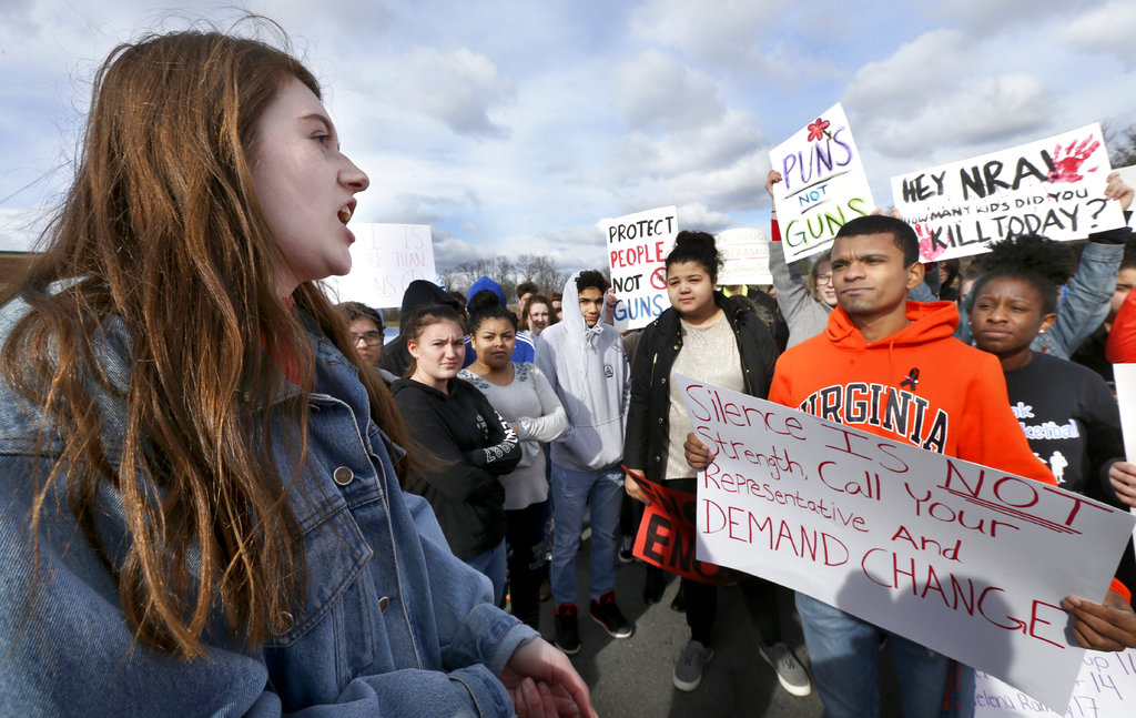 Senior Carly Kaderi, left, speaks to classmates as they participate in a walkout to protest gun violence, Wednesday, March 14, 2018, at Millbrook High School in Winchester, Va., Wednesday, March 14, 2018, one month after the deadly shooting inside a high school in Parkland, Fla.