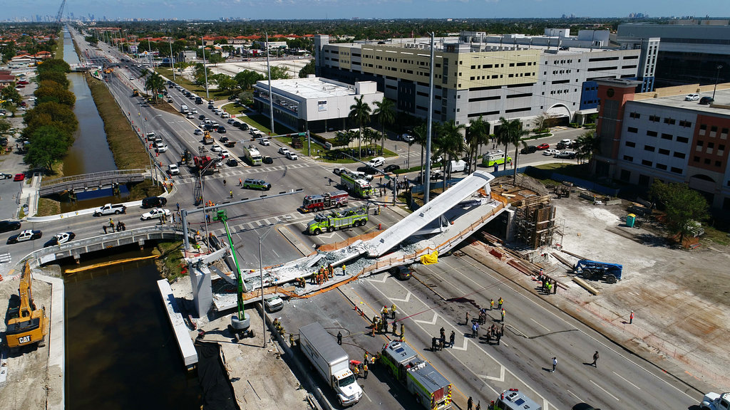 FILE- This March 15, 2018 file photo shows the main span of the a pedestrian bridge after it collapsed over several cars causing fatalities and injuries. Documents obtained by The Associated Press through a public records request show that the Florida Department of Transportation in October 2016 ordered Florida International University and its contractors to move the bridge's main, signature pylon 11 feet north to the edge of a canal, widening the distance the crossing would gap between its supports and requiring a new base structural design. .