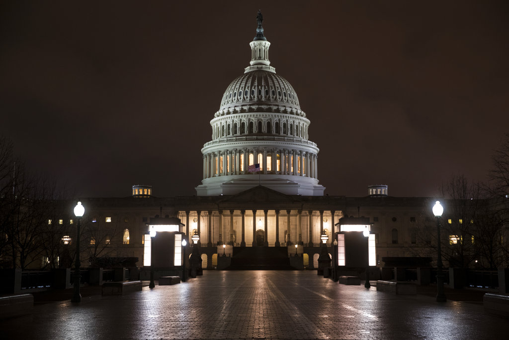 The Capitol is seen before dawn Wednesday after a night of negotiating on the government spending bill, in Washington, March 21, 2018. Talks over a $1.3 trillion omnibus bill are almost complete as the White House and Capitol Hill Democrats ironed out deals on a first round of funding for President Donald Trump's U.S.-Mexico border wall. (AP Photo/J.