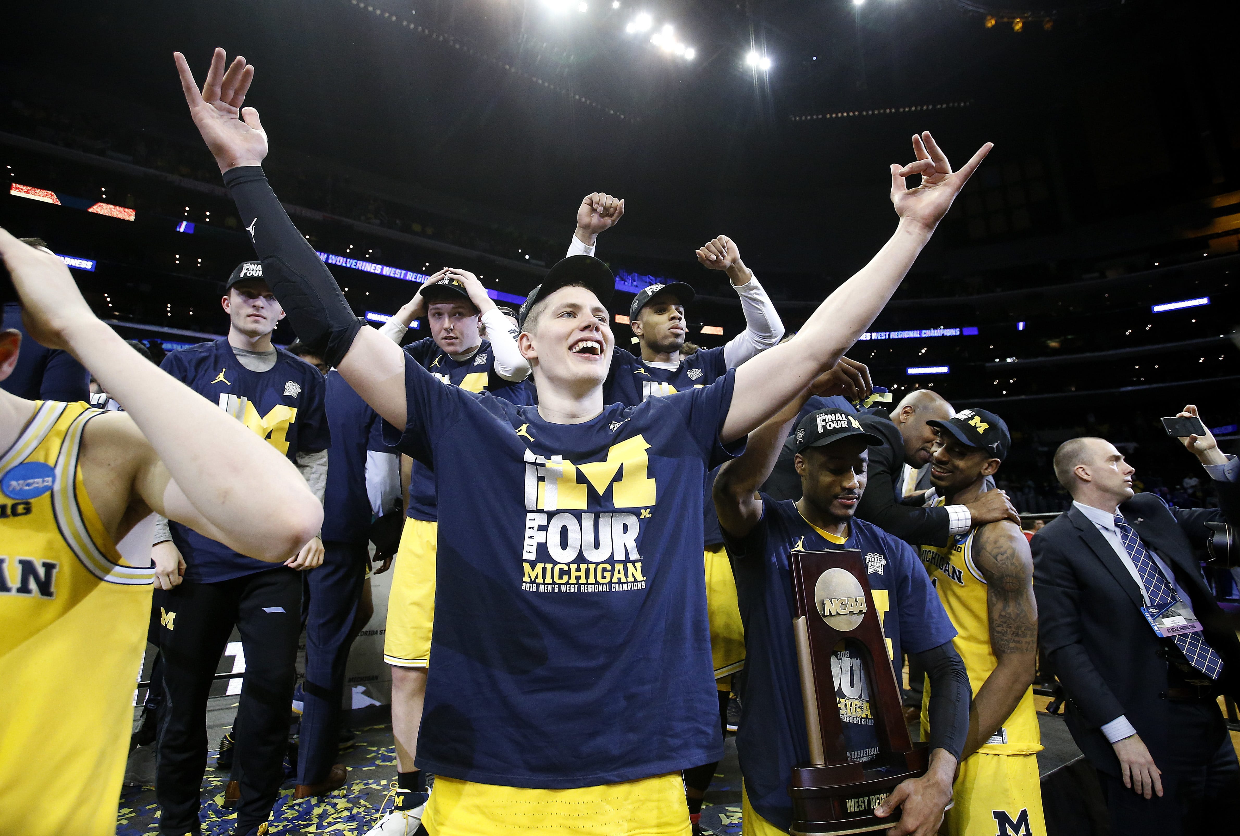 Michigan forward Moritz Wagner, foreground, and teammates celebrate after defeating Florida State 58-54 in an NCAA men's college basketball tournament regional final Saturday, March 24, 2018, in Los Angeles.