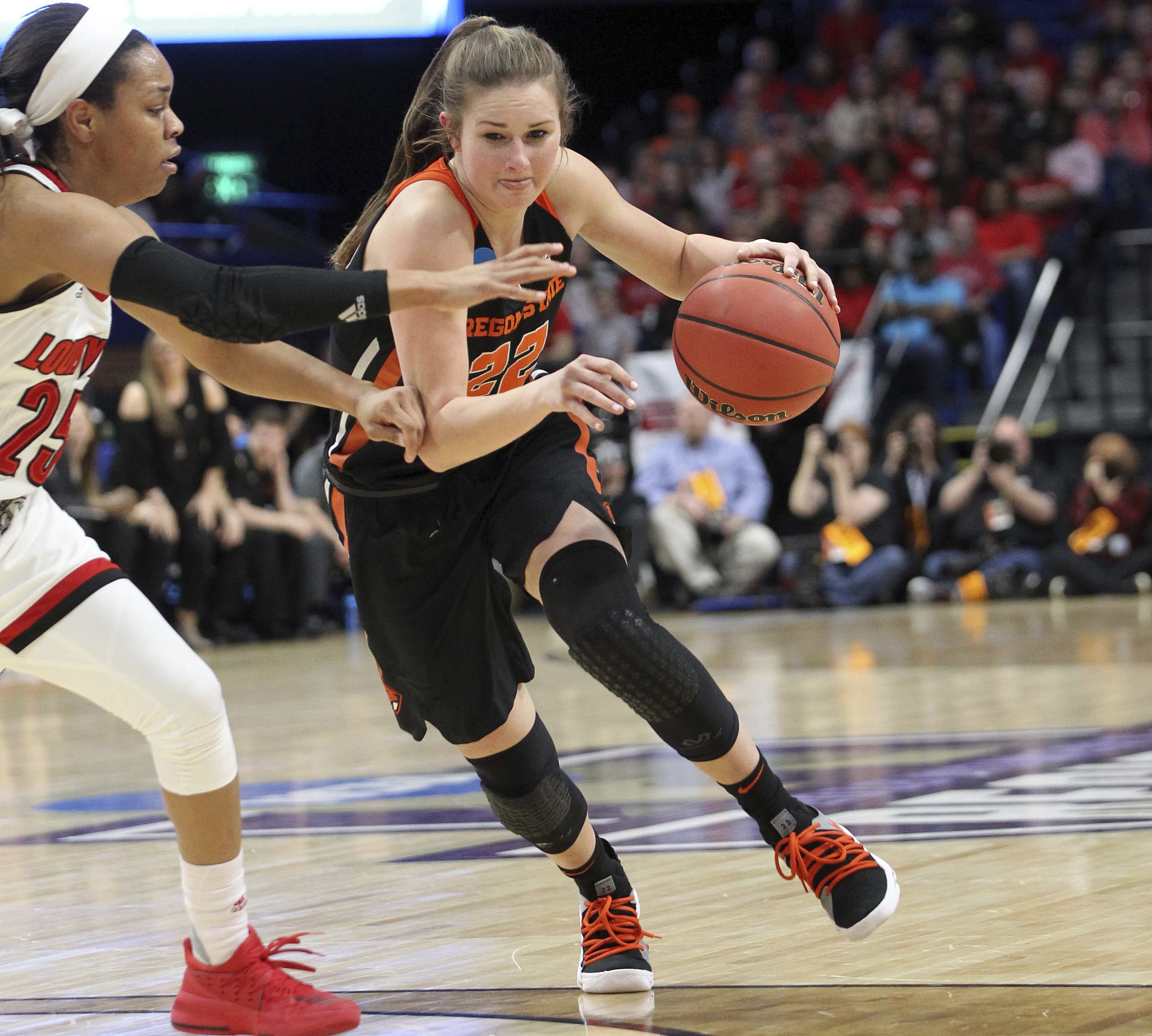 Oregon State's Kat Tudor, right, drives on Louisville's Asia Durr during the first half of an NCAA women's college basketball tournament regional final, Sunday, March 25, 2018, in Lexington, Ky.