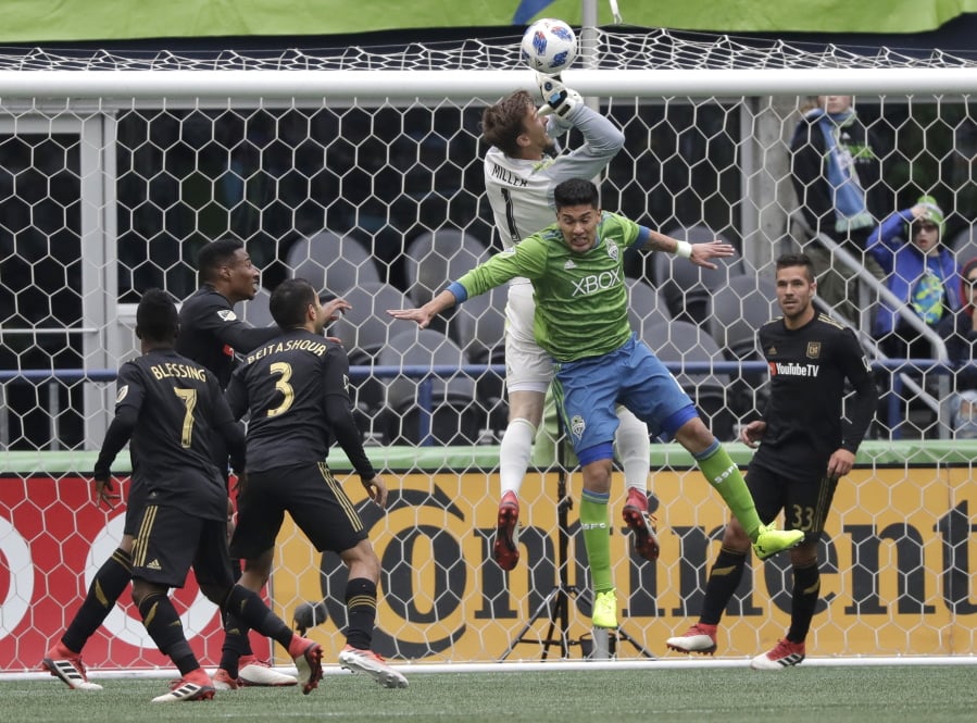 Seattle Sounders defender Tony Alfaro, second from right, collides with Los Angeles goalkeeper Tyler Miller (1) during the first half of an MLS soccer match, Sunday, March 4, 2018, in Seattle. (AP Photo/Ted S.