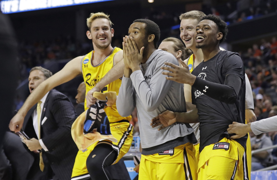 UMBC players celebrate a teammate’s basket against Virginia during the second half of a first-round game in the NCAA men’s college basketball tournament in Charlotte, N.C., Friday, March 16, 2018.