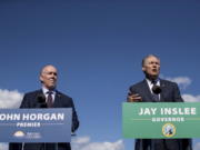 British Columbia Premier John Horgan, left, listens as Washington Gov. Jay Inslee speaks Friday in Vancouver, B.C., during a news conference about high-speed rail.