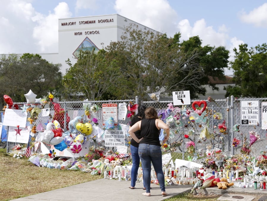 A memorial for the victims of the Feb. 14 shooting lines a fence at Marjory Stoneman Douglas High School in Parkland, Fla.