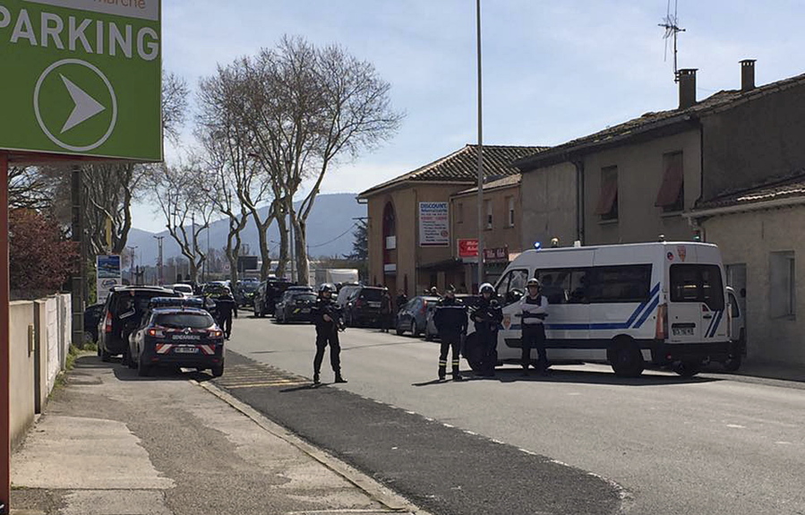 In this image provided by Newsflare/Tarbouriech Roseline police attend an incident in Trebes, southern France, Friday March 23, 2018. An armed man took hostages in a supermarket in southern France on Friday, killing two and injuring about a dozen others, police said.