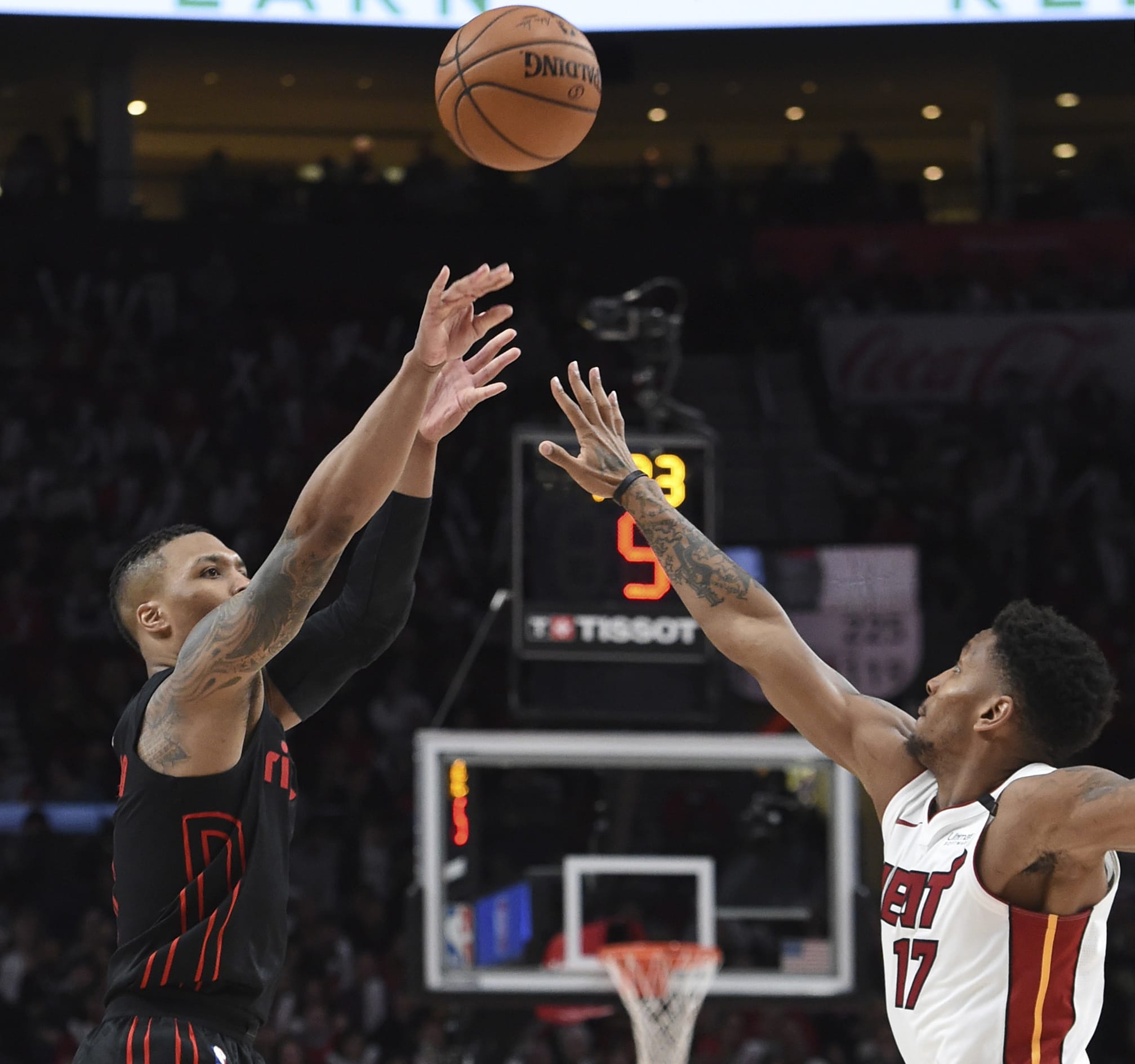 Portland Trail Blazers guard Damian Lillard hits a 3-point shot over Miami Heat guard Rodney McGruder during the second half of an NBA basketball game in Portland, Ore., Monday, March 12, 2018. The Blazers won 115-99.