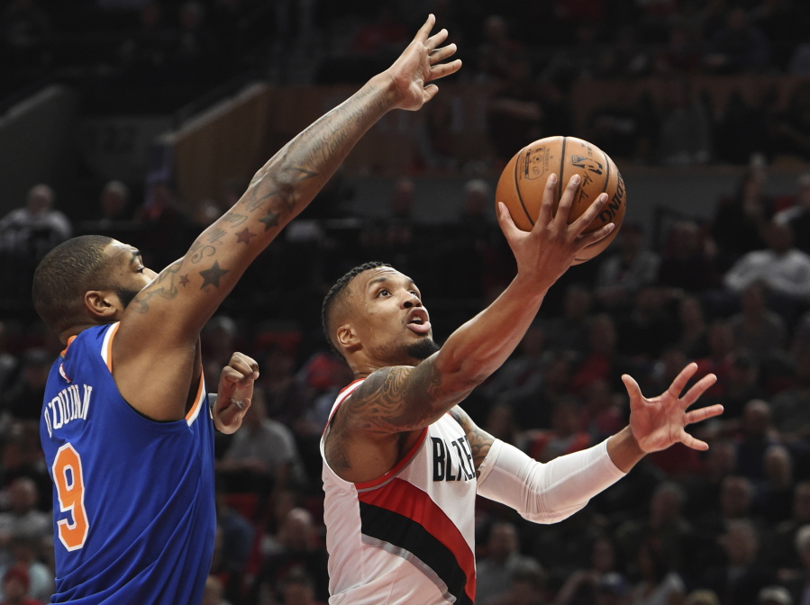 Portland’s Damian Lillard drives to the basket on New York Knicks center Kyle O’Quinn during the second half Tuesday. Lillard scored 37 points in the Blazers’ win.