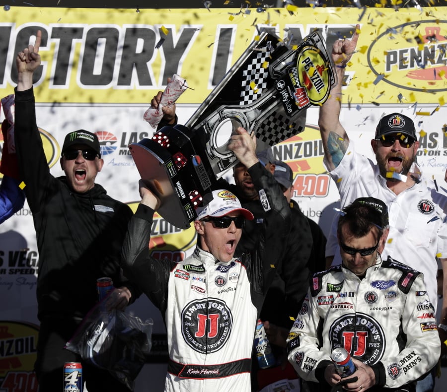 Kevin Harvick hoists the trophy with his team after winning a NASCAR Cup series auto race Sunday, March 4, 2018, in Las Vegas.