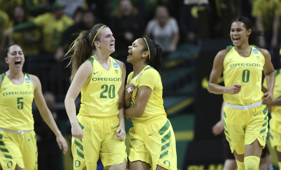 Oregon’s Maite Cazorla, Sabrina Ionescu, Justine Hall and Satou Sabally, from left, celebrate a buzzer-beating 3-point shot by Ionescu during the first half of a second-round game against Minnesota in the NCAA women’s college basketball tournament in Eugene, Ore., Sunday, March 18, 2018.