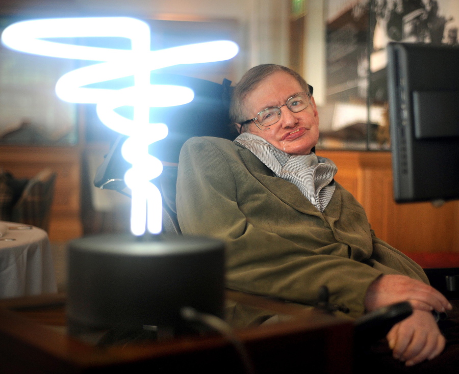 Professor Stephen Hawking poses Feb. 25, 2012, beside a lamp titled “black hole light” by inventor Mark Champkins, presented to him during his visit to the Science Museum in London. Hawking died March 14 at age 76.
