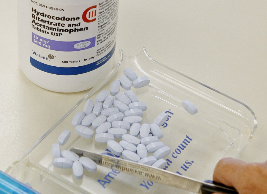 A pharmacy technician poses for a picture with hydrocodone and acetaminophen tablets, also known as Vicodin, at the Oklahoma Hospital Discount Pharmacy in Edmond, Okla. Opioids including Vicodin and fentanyl patches worked no better than Tylenol and other over-the-counter pills at relieving chronic back pain and hip and knee arthritis in a year-long study of mostly men at Minneapolis VA clinics. Both groups had slight improvement.