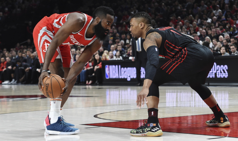 Houston Rockets guard James Harden looks to get past Portland Trail Blazers guard Damian Lillard during the first half Tuesday in Portland. The Rockets won 115-111 for their sixth straight win and their 23rd in 24 games.