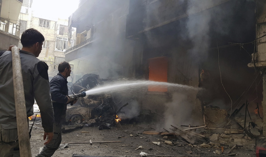 This photo released by the Syrian Civil Defense White Helmets, which has been authenticated based on its contents and other AP reporting, Civil Defense workers putting out a fire following airstrikes and shelling in Douma, in the eastern Ghouta region near Damascus, Syria, Tuesday, March. 20, 2018. The U.N. refugee agency says 45,000 Syrians have left their homes in the besieged region of eastern Ghouta in recent days, amid a Syrian government-led offensive against the rebel-held area.