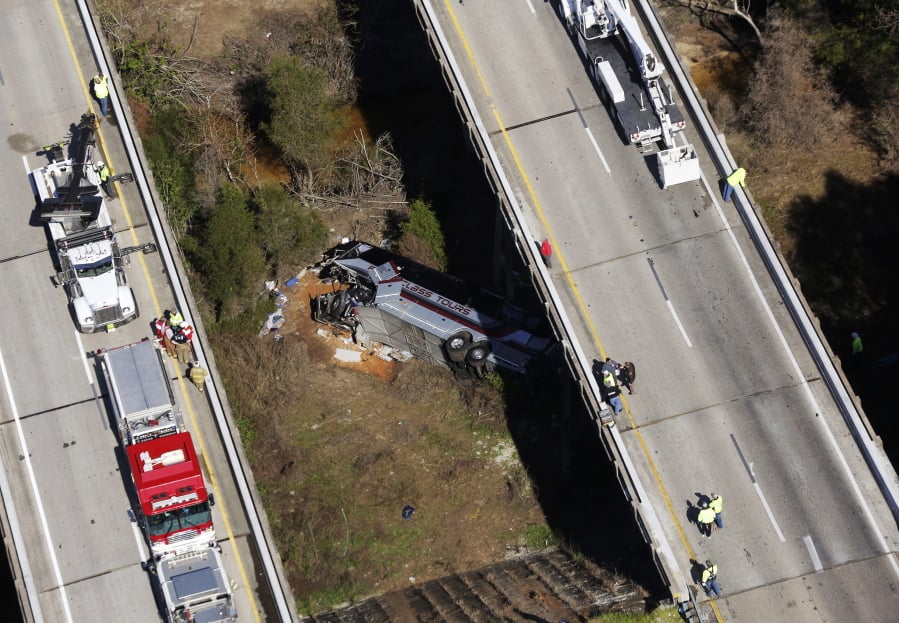 Rescue crews look down on a charter bus that plunged off the highway Tuesday in Loxley, Ala.