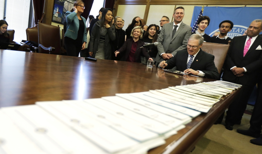 A long line of bills are placed on a table in the Governor’s conference room at the Capitol in Olympia on Wednesday. Ted S.