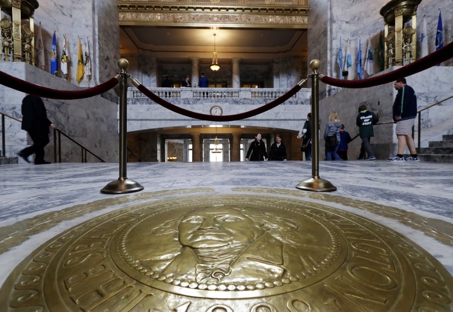 Visitors walk past the Washington state seal in the Capitol Rotunda on Thursday at the Capitol in Olympia on the final day of the regular session of the Legislature.
