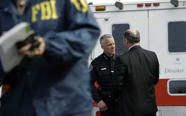 Interim Austin police chief Brian Manley, left, talks with FBI Special Agent in Charge Christopher Combs, right, near the site of Sunday's explosion, Monday, March 19, 2018, in Austin, Texas. Fear escalated across Austin on Monday after the fourth bombing this month — this time, a blast that was triggered by a tripwire and demonstrated what police said was a "higher level of sophistication" than the package bombs used in the previous attacks.