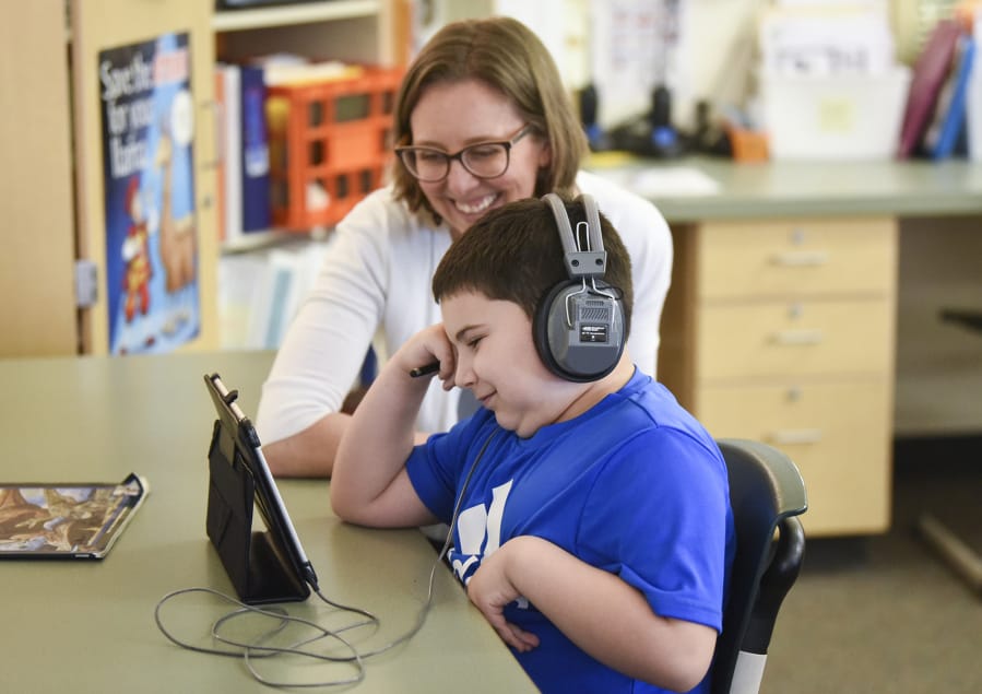 Kim Brown, a special education teacher at Felida Elementary School, smiles as she watches second-grader Zain Thompson, 8, succeed in building a bridge in an exercise on Code.org during class  in 2018.