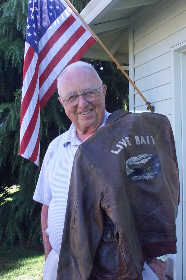 Clayton Kelly Gross drapes his “Live Bait” flight jacket over his shoulder in a 2002 photograph. The jacket is now in the National WWII Museum.