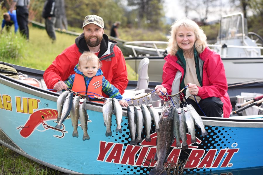 Jason Resser, (left) his son Zayn, and Maggie Ramsey show off their catch from last year’s trout opener at Rowland Lake. The official lowland lakes trout opener is this Saturday. Some 12 million trout and kokanee have been stocked since fall in Washington’s lakes.