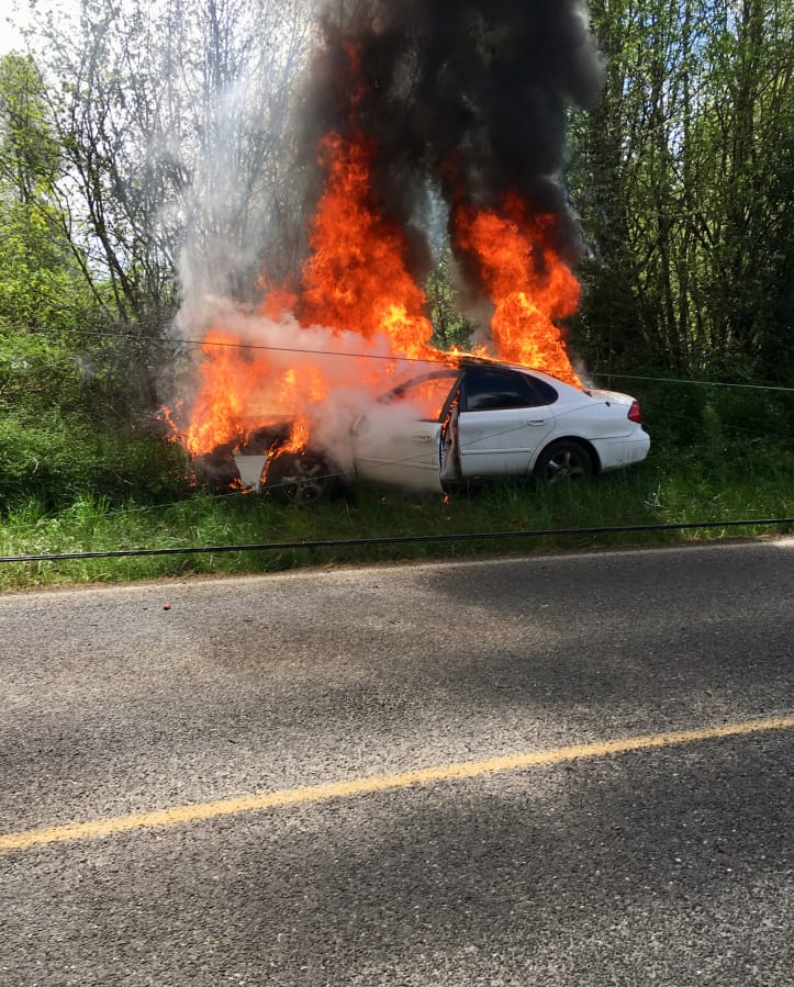A car burns after crashing into a power pole Sunday afternoon near Battle Ground. No injuries were reported, but a few hundred customers were without power for a time following the crash.