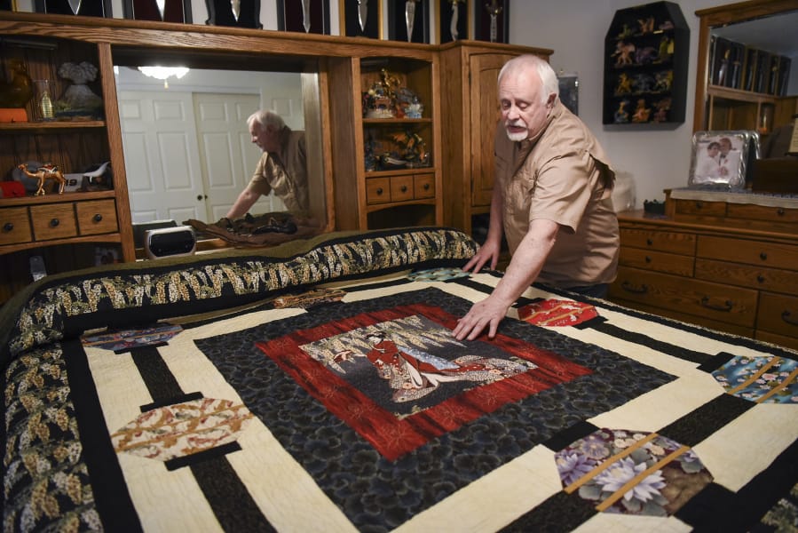 John Hatfield, 71, describes an Asian-style quilt he made over the course of seven months in his bedroom at his home in Vancouver. Hatfield, a prize-winning member of the Clark County Quilters, bought the fabric in the center of the quilt first, then added on sections as he went.